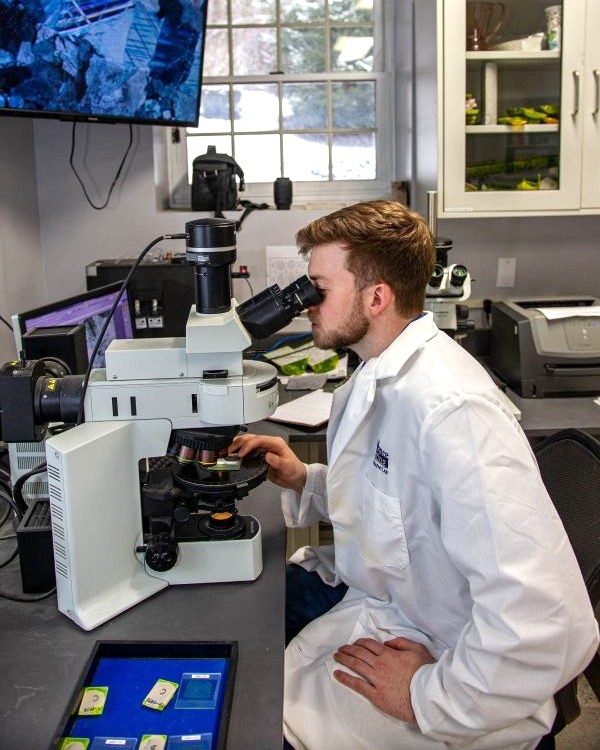 petrographic analysis by petrographer reviewing samples under microscope
