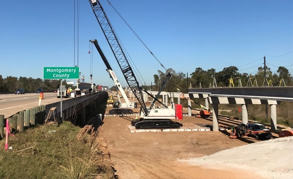 Multiple cranes working on a highway bridge construction