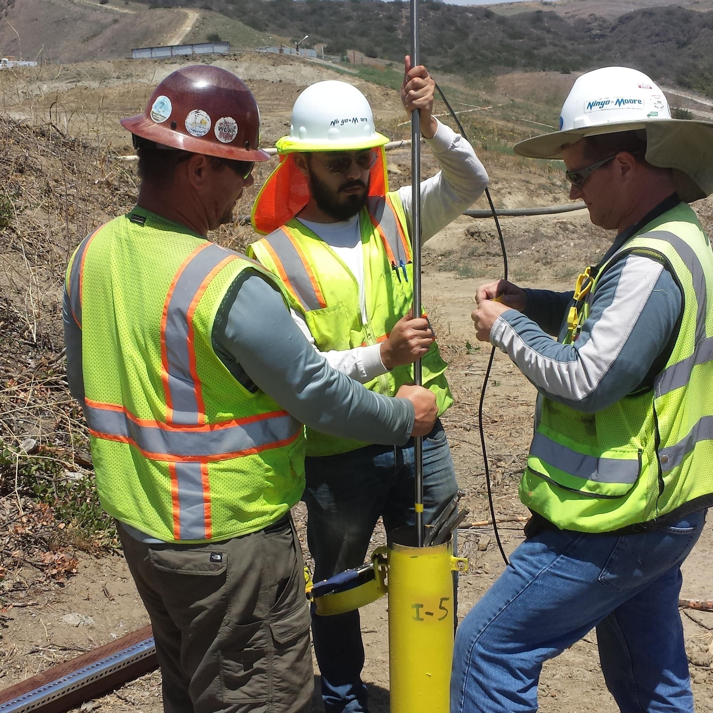 Field technicians installing and measuring geotechnical instrumentation
