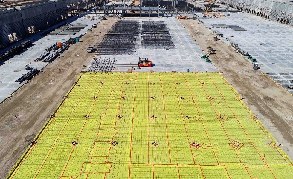 Aerial view of a construction site showing large concrete slab preparation