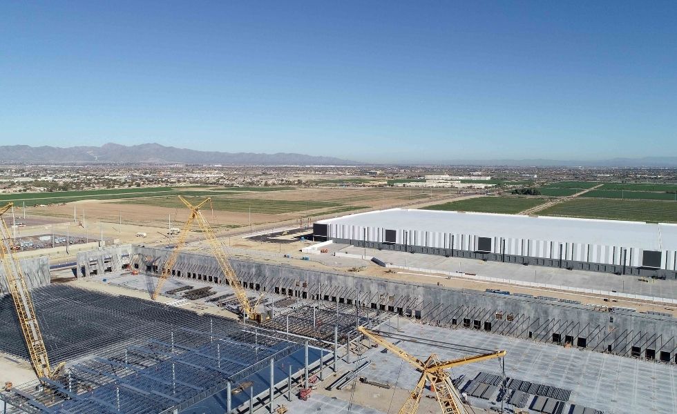 Aerial view of a large industrial construction site showing structural steel framing