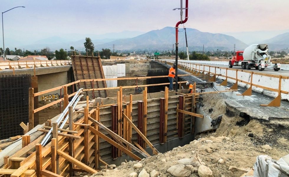 Construction workers placing concrete using a pump truck