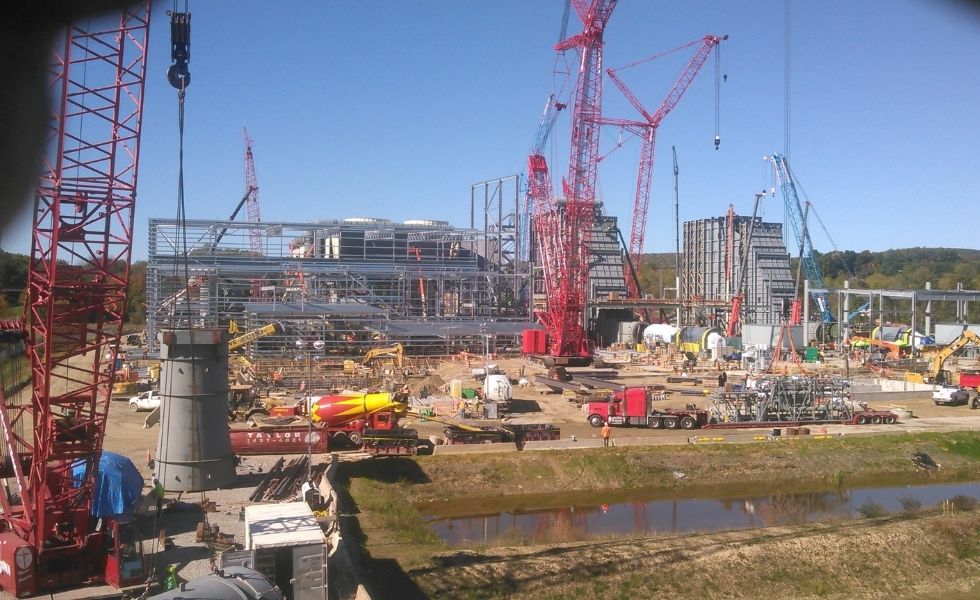 Wide view of the CPV Valley Energy Center construction site in Waywayanda, New York, showing cranes, structural steel installation, concrete work, and power plant infrastructure under construction.