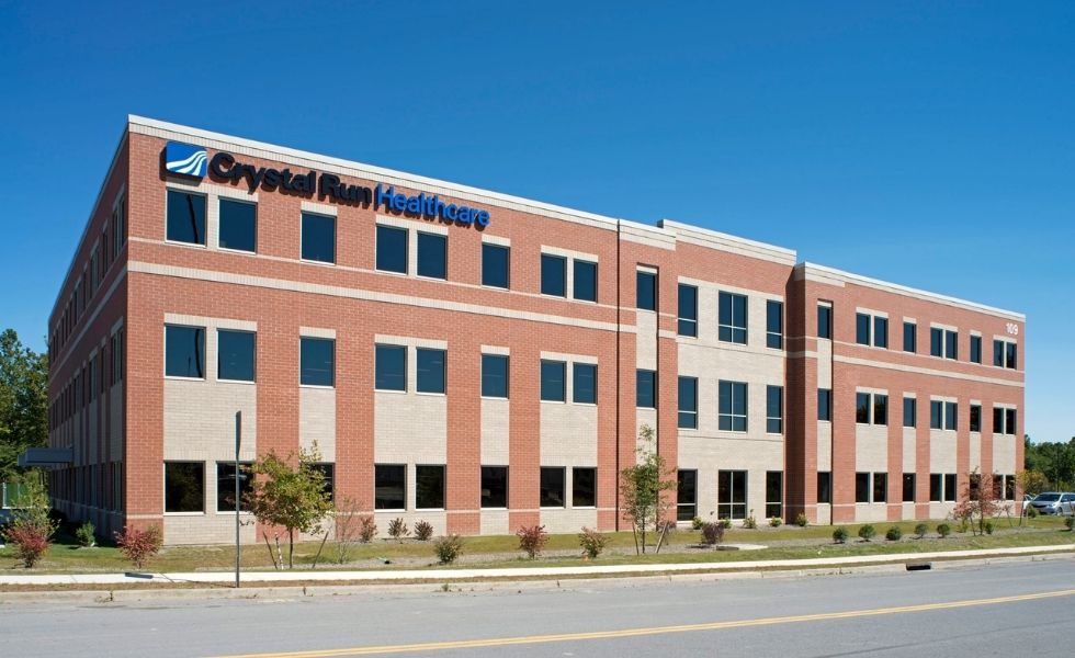 Exterior view of the Crystal Run Healthcare medical office building in New York, featuring a three-story brick façade