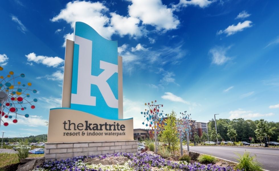 Main entrance sign and arrival area at The Kartrite Resort & Indoor Water Park, NY, featuring landscaped grounds