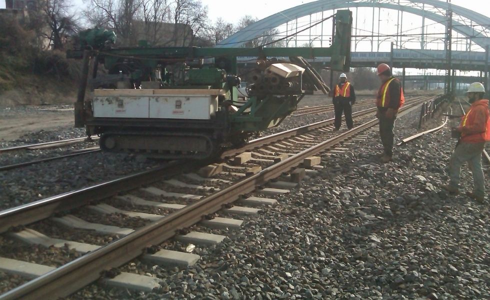 41st Street Bridge project: field personnel and track-mounted drilling equipment performing geotechnical investigation activities within an active rail corridor near the bridge structure.
