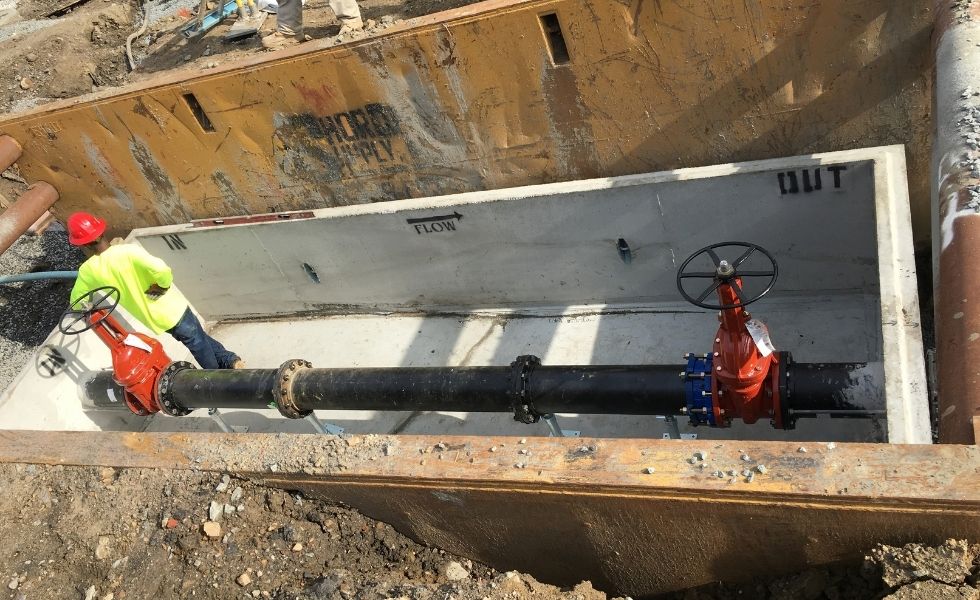 Underground utility vault with large water pipeline and red gate valves under installation at the Philaport Auto Facility project