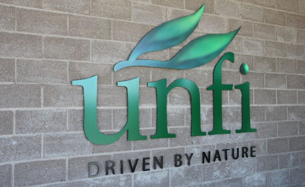 UNFI logo and “Driven by Nature” signage displayed on the exterior wall of the United Natural Foods Distribution Facility in Wallkill, New York.