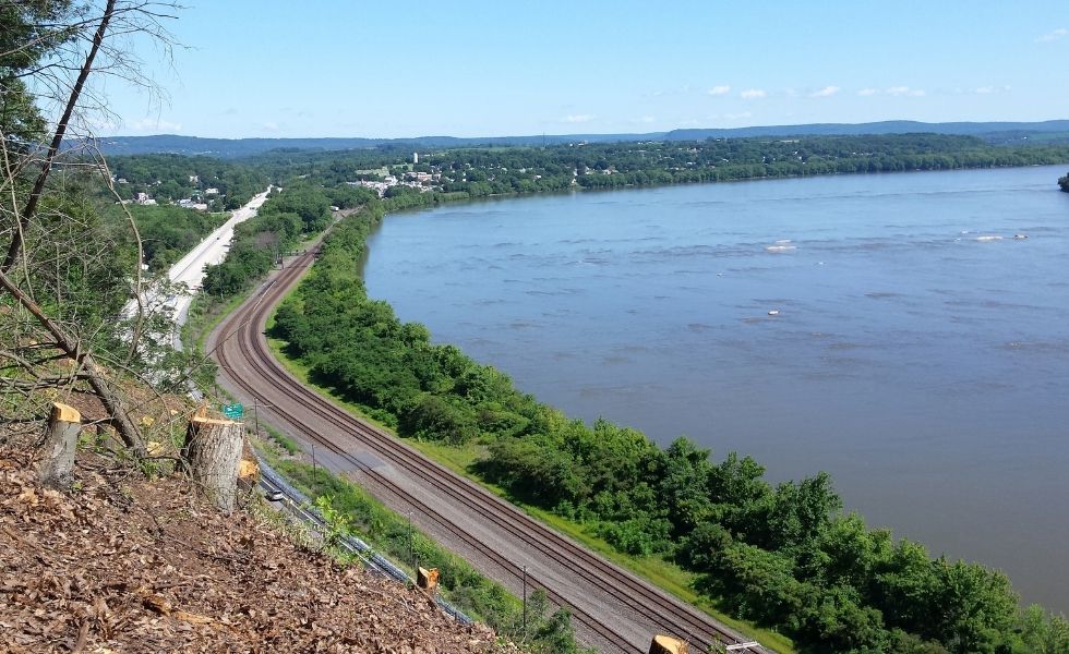 US 11/15 Rock Slope Safety Improvement, PA project: overview of the transportation corridor, railway tracks, roadway, and adjacent river viewed from the stabilized rock slope area.