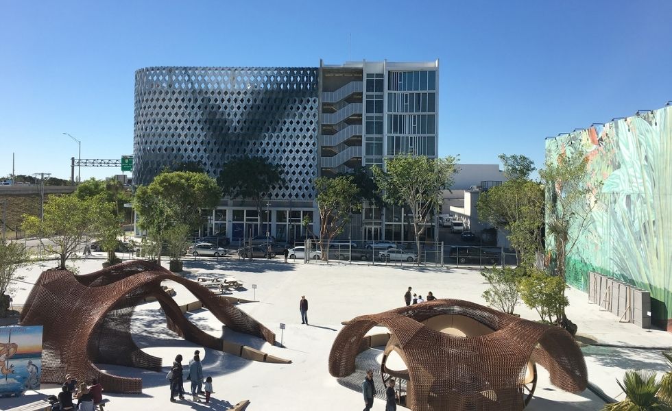 A spacious public plaza within the Miami Design District featuring sculptural art installations, landscaped gathering areas