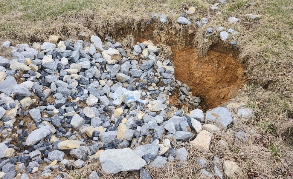 Exposed sinkhole and erosion feature documented during the Open-End Geotechnical Services Contract, showing rock fill, soil loss, and subsurface instability
