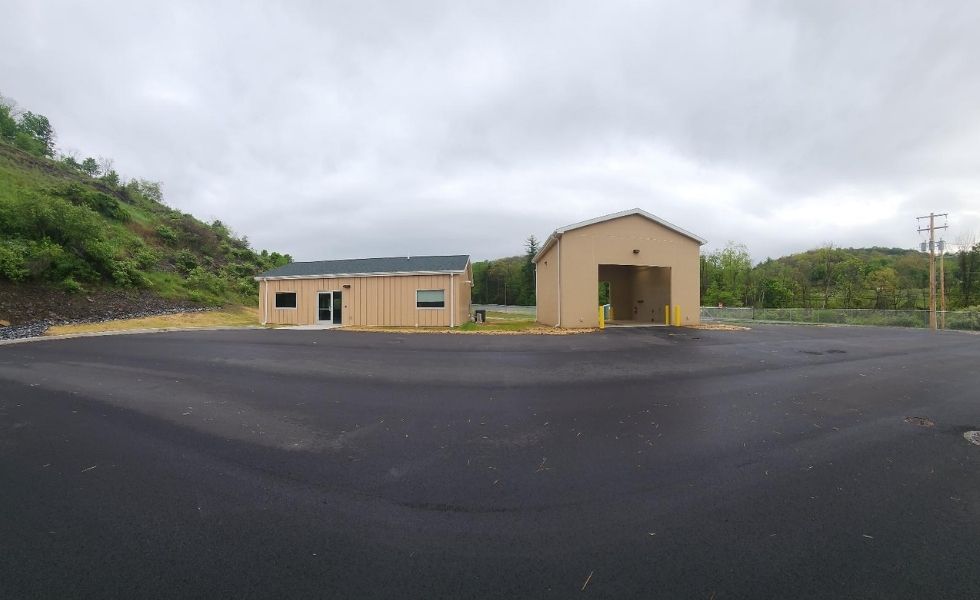 View of the maintenance garage and paved service yard at the STEP Williamsport Transportation Facility in Pennsylvania, showing a large operations building