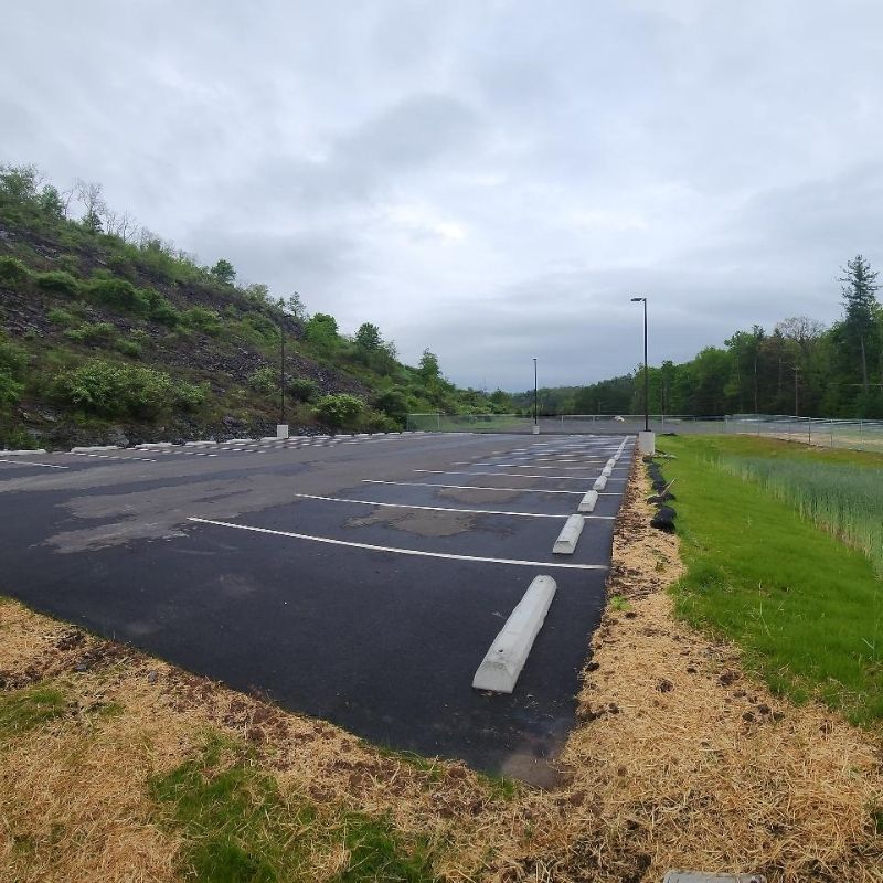 Parking area and landscaped stormwater management features at the STEP Williamsport Transportation Facility in Pennsylvania, showing newly paved parking spaces