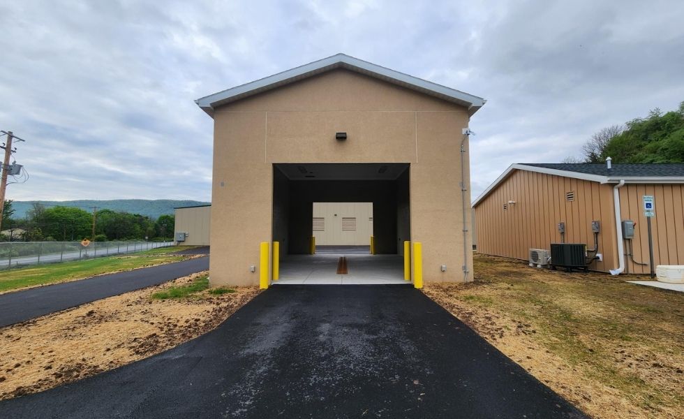 Front view of the vehicle wash bay at the STEP Williamsport Transportation Facility in Pennsylvania, featuring a covered drive-through structure, adjacent operations building