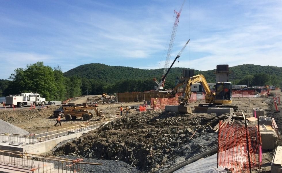 World Headquarters Construction project site showing cranes, excavators, foundation work and construction workers