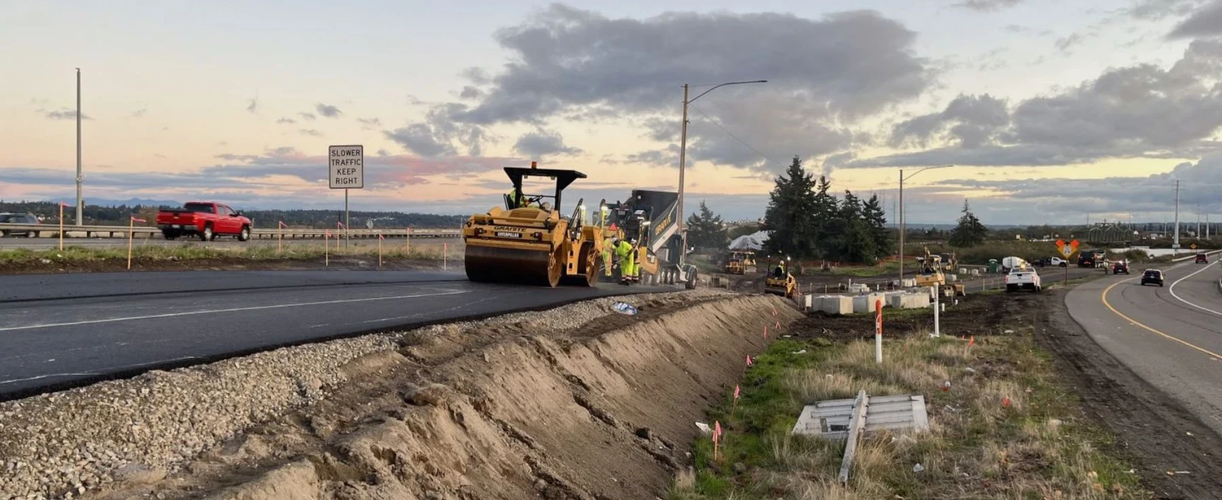 Road construction crews using heavy machinery to pave a multi‑lane highway