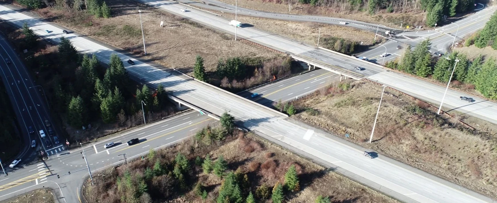 Aerial view of the I-90 – SR 18 Interchange Improvements project in Snoqualmie Valley, Washington, showing highway bridges, interchange ramps, surrounding forested areas, and regional transportation infrastructure.