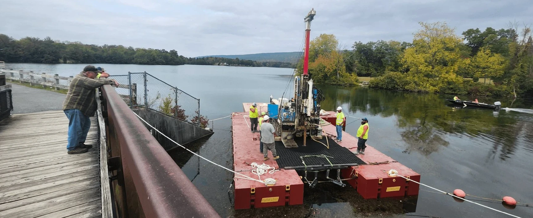 Memorial Lake Dam, PA: geotechnical investigation activities on a floating drilling platform near the dam, supporting dam safety assessment and infrastructure evaluation.