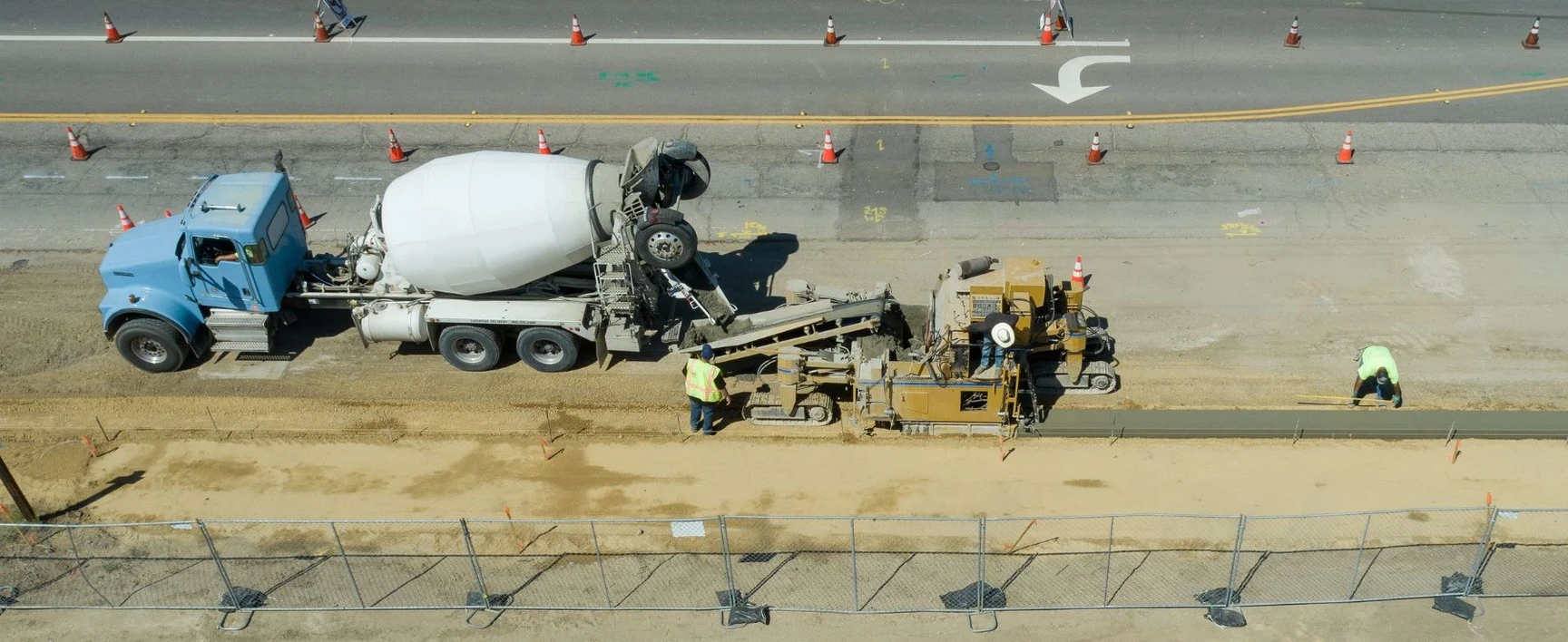 SR 167 Corridor Improvements Project, WA: concrete paving operations along a roadway corridor with a concrete mixer truck, paving equipment, traffic control devices, and construction personnel