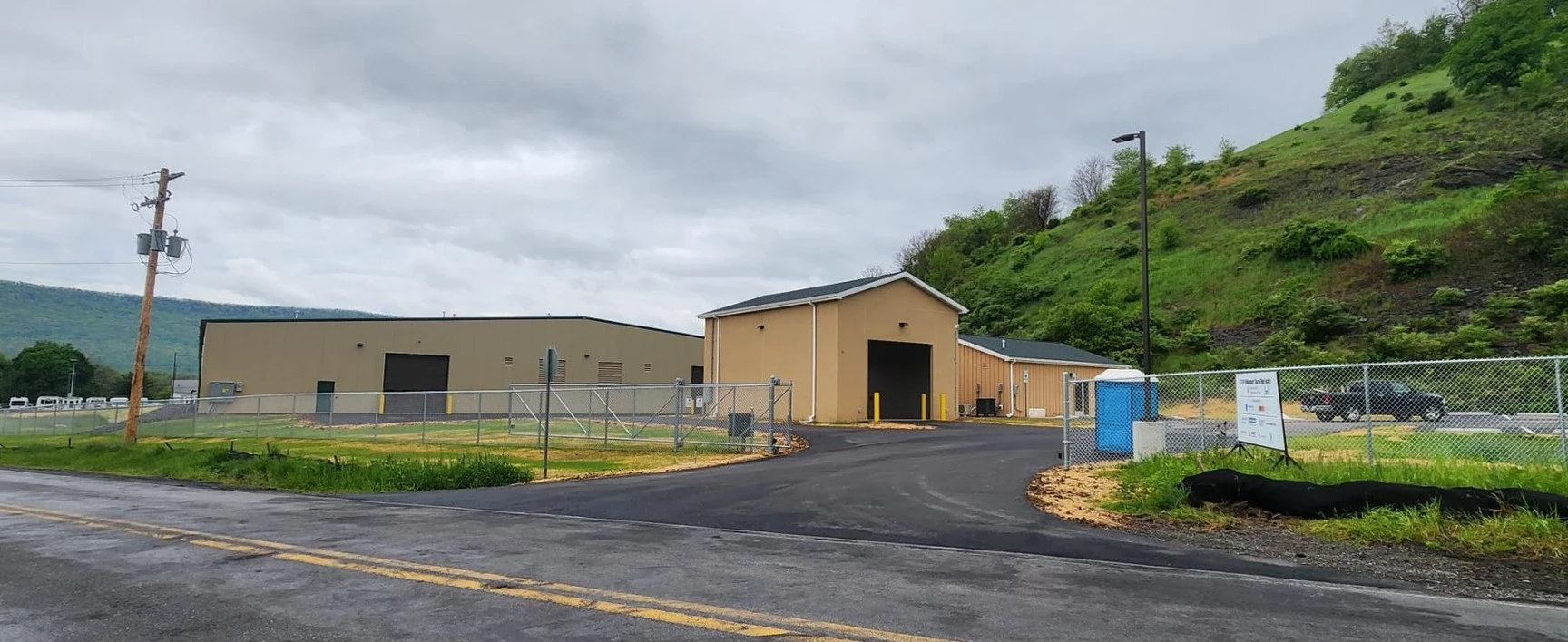 Exterior view of the STEP Williamsport Transportation Facility in Pennsylvania, featuring newly constructed maintenance and operations buildings behind a fenced perimeter