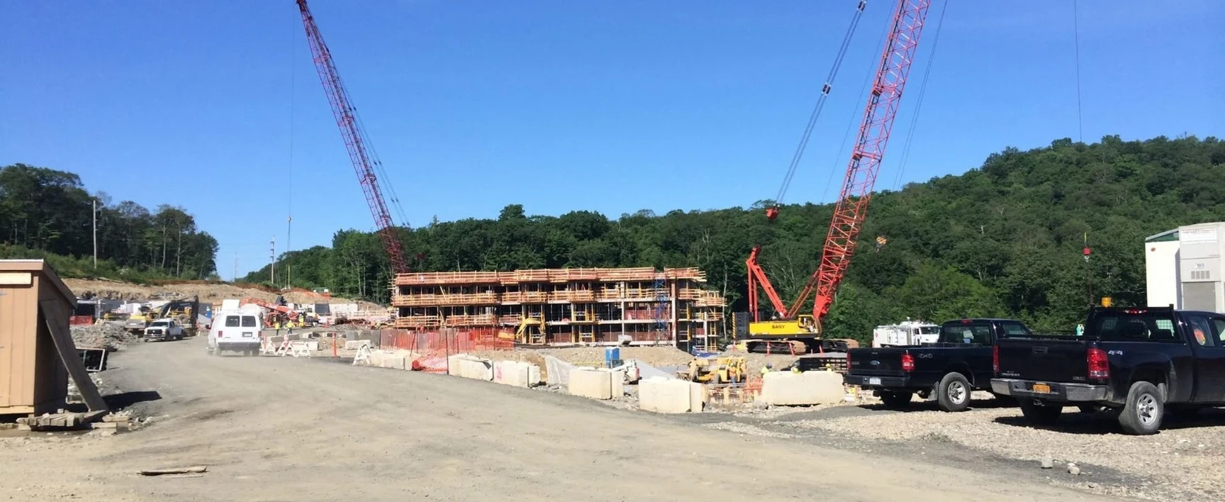 World Headquarters Construction project site in New York, showing a multi-story building under construction with cranes, construction vehicles, and equipment