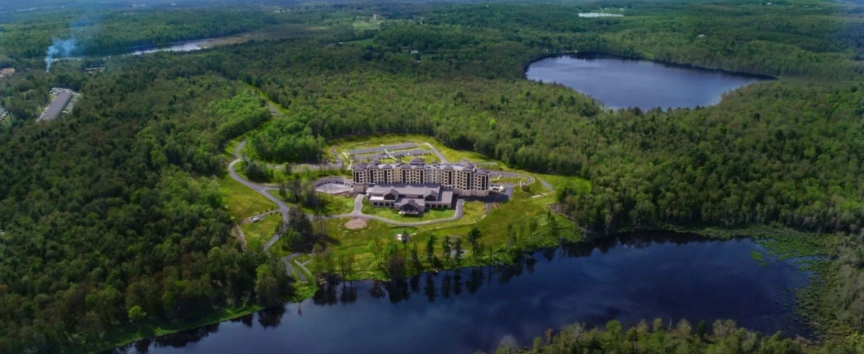 Aerial view of the YO1 Wellness Resort & Spa, surrounded by dense forest and lakes in the Catskills