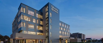 A multi‑story hospital building with large windows, photographed at dusk