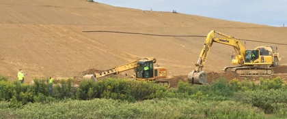 Lebanon Landfill project showing excavation and earthmoving operations on a large landfill slope, with a Komatsu excavator, a Gradall machine.