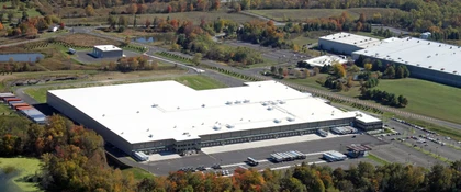 Aerial view of the United Natural Foods Distribution Facility in Wallkill, NY, showing a 525,000-square-foot refrigerated distribution warehouse with loading docks, trailer parking.