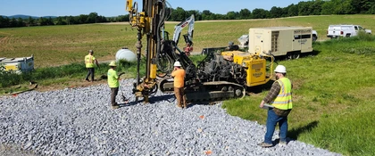 Drilling crew performing subsurface investigations for the Open-End Geotechnical Services Contract, with geotechnical drilling equipment, support vehicles, and field personnel collecting site data.