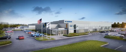 Exterior view of the McKesson distribution center, featuring a large modern industrial facility, parking areas, and McKesson signage and flags at the main entrance.